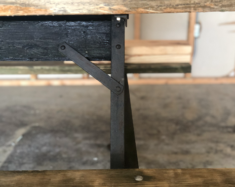 Picture of a side of a wooden table with metal legs